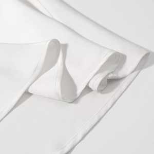Détail de la couture de l'ourlet sur une robe en satin blanc avec une texture de tissu fine