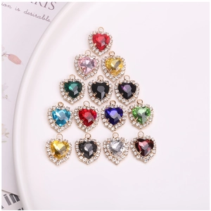 Macro shot of colorful heart-shaped crystal charms with cubic zirconia borders for DIY jewelry