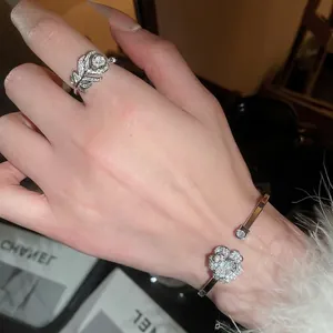 Elegante set bracciale a fiore e anello a piuma in argento con zirconi scintillanti