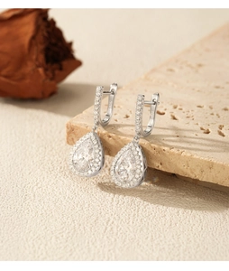 Detailed macro view of S925 hallmark on pear-shaped silver drop earrings with crystals