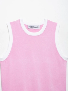 Détail d'un débardeur en maille rose avec bordures côtelées blanches au col et emmanchures
