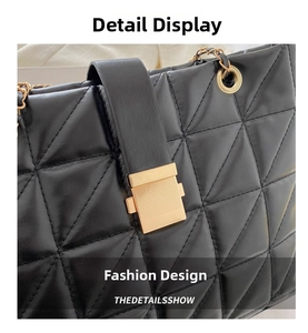 Close-up of black quilted leather texture and gold metal buckle on chain strap bag