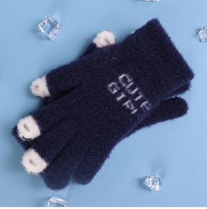 Detailed shot of blue knitted winter gloves with white CUTE GIRL text and fingertips