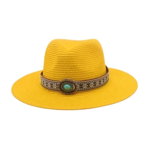 Détail d'un chapeau de paille jaune avec pierre turquoise et ruban de style bohème