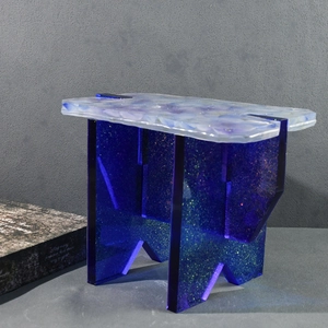 Detail of DIY epoxy resin square stool showing blue glitter legs and marbled seat texture