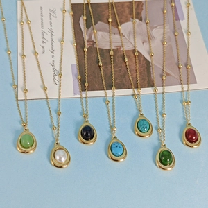 Golden beaded necklaces with colorful teardrop gemstone pendants in various elegant hues