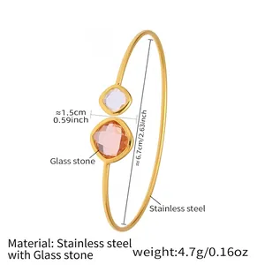 Detail view of gold stainless steel open bangle with orange and purple glass stones