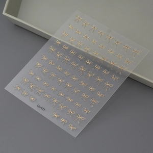 Détail d'autocollants pour ongles avec nœuds dorés et texture métallique en relief, Co-121