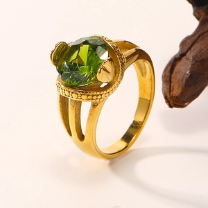 Detailed close-up of 18K gold-plated snake ring featuring a large green faceted zircon stone