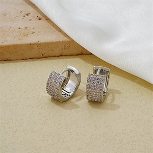 Silver huggie earrings with multi-row pavé zircon crystals on textured stone base