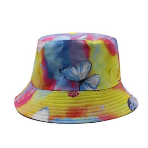 Détail d'un chapeau bob tie-dye coloré avec motifs papillons bleus et bord surpiqué