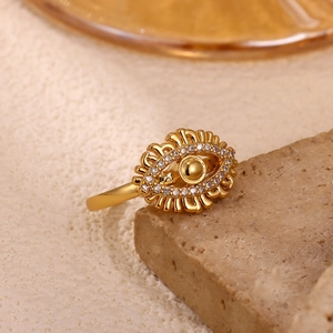 Macro shot of gold Evil Eye ring featuring zircon pavé settings and wave-textured edges