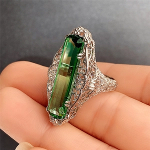 Macro d'une bague zircon vert taille émeraude avec des détails de filigrane vintage