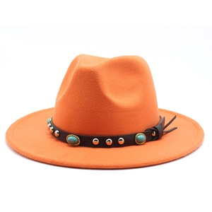Detail of orange fedora wool hat featuring black leather band and turquoise stone studs