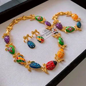 Vintage gold bow jewelry set with colorful enamel egg pendants including necklace and earrings