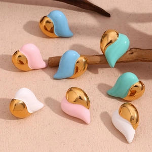 Detailed macro view of heart-shaped enamel earrings in diverse pastel colors with gold plating