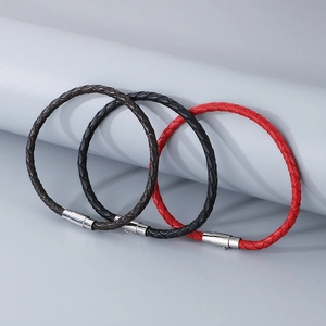 Détail de bracelets en cuir tressé noir, marron et rouge avec fermoirs magnétiques en métal