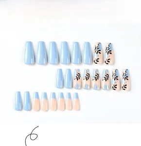 Detail of blue and pink long ballerina false nails with gold leaf and black leaf patterns
