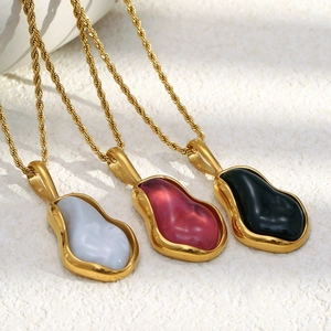Close-up of three fluid baroque pearl pendants in blue, red and black with gold finish