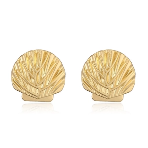 Close-up of gold scallop shell stud earrings with detailed radial ribbed texture