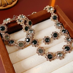 Detail of vintage gold jewelry set with green stones in a luxury gift box display