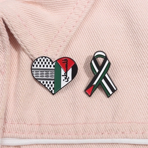Minimalist Palestine heart and ribbon enamel pins set on pink denim background