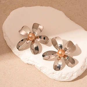 Elegant silver metal flower stud earrings with champagne pearl center on white stone