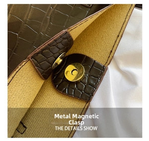 Close-up of golden magnetic buckle on dark brown crocodile pattern leather handbag