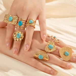 Gold vintage snake and heart ring set with turquoise stones on beige silk fabric