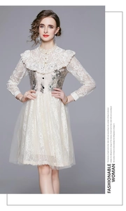 Detail of vintage French style dress featuring lace ruffles and floral embroidery