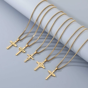 Detail of five gold stainless steel cross necklaces with crystal inlays on blue display