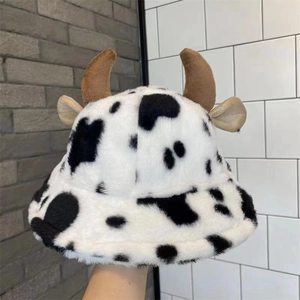 Dettaglio di un cappello da pescatore in peluche con motivo mucca e corna marroni