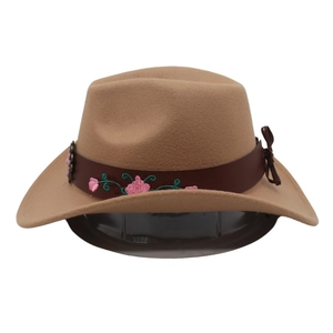 Detail view of camel wool cowboy hat with floral embroidery on a brown leather band