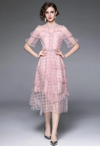 Détail de la robe en dentelle rose avec broderie de fil doré et poignets à volants