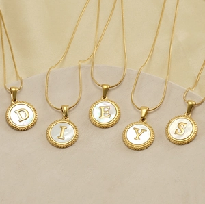 Detail of 18K gold stainless steel snake chains with white shell alphabet pendants