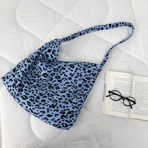 Detail of trendy leopard print canvas bag with wide shoulder strap on bed