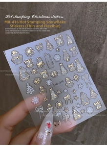 Nahaufnahme goldener Weihnachts-Nagelaufkleber mit Schneeflocken und Rentier-Motiv