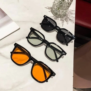Fashionable oversized square sunglasses set in black, orange, and light green lenses