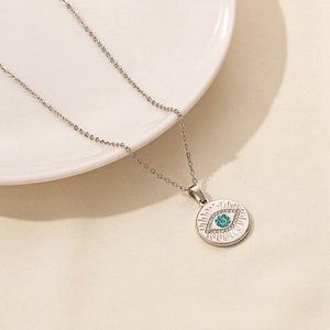 Detailed shot of silver evil eye necklace with blue gemstone and sparkling zircon stones
