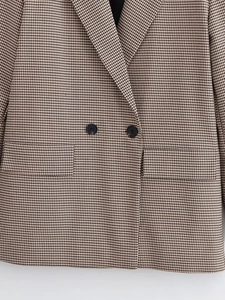 Détail du blazer à motif pied-de-poule avec boutons croisés et poches à rabat