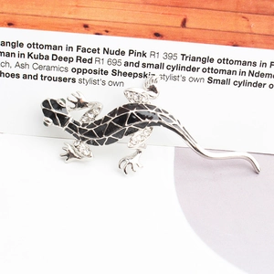 Close-up of a lizard brooch featuring silver alloy with black enamel and sparkling rhinestones