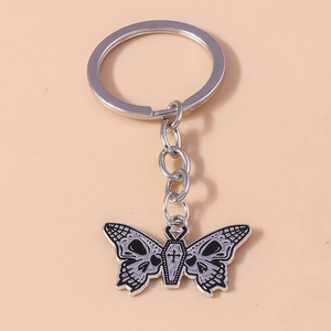 Detail of gothic silver butterfly keychain with skull and coffin cross motifs
