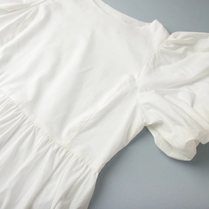 Vue détaillée de la robe en coton blanc avec manches bouffantes et taille plissée