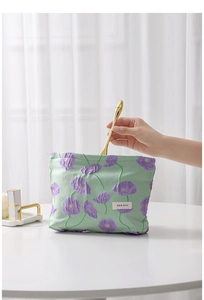 Detail of green canvas floral makeup bag showing H&R BAG label and interior storage
