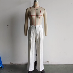 Detail view of white wide-leg straight trousers with textured fabric and clean tailoring