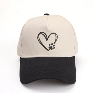 Détail de la casquette bicolore avec broderie cœur et patte sur toile beige clair