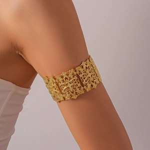 Détail d'un bracelet de bras bohème doré avec des motifs de fleurs ajourées complexes