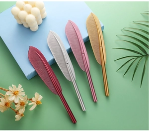 Creative metal feather gel pens in gold silver pink and red on a mint green background