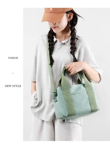 Detail of mint green canvas handbag with reinforced handles and adjustable shoulder strap