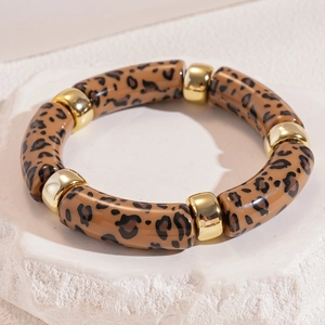 Detail of acrylic leopard print tube bracelet with polished gold metal spacers on stone